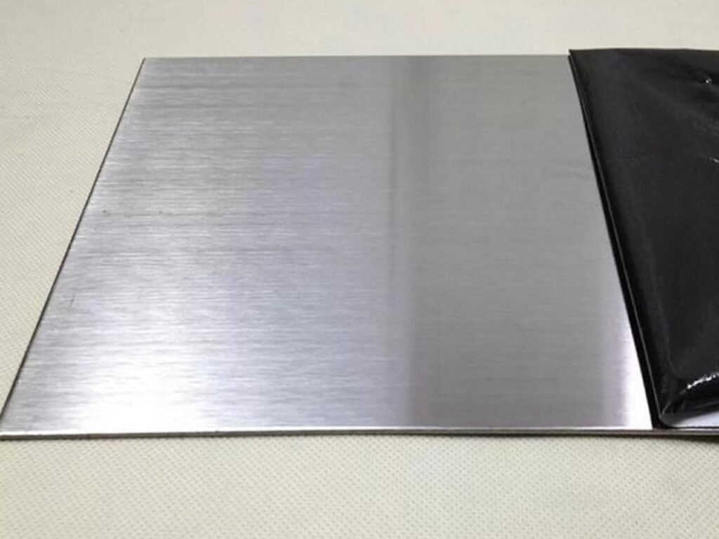 Brushed stainless steel sheet metal panel showing a uniform linear surface finish and reflective metallic appearance.