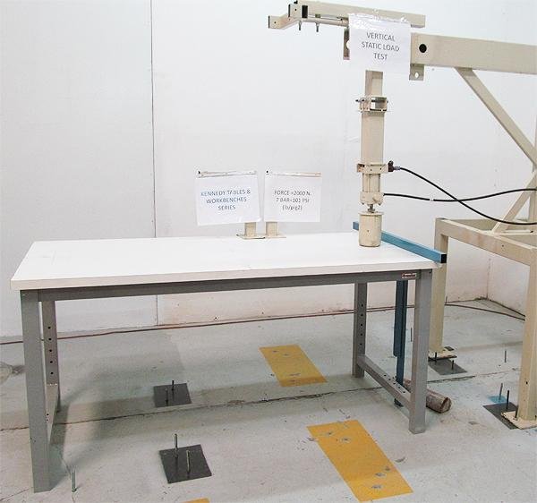 Laboratory workbench undergoing a vertical static load test to evaluate structural performance under an applied load.